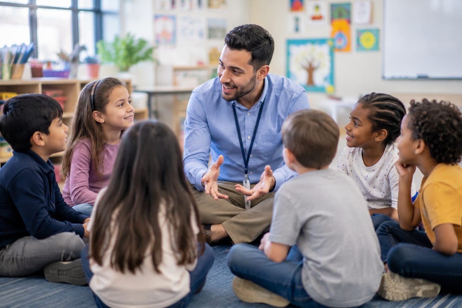 A teacher sitting in a circle with pupils, talking together